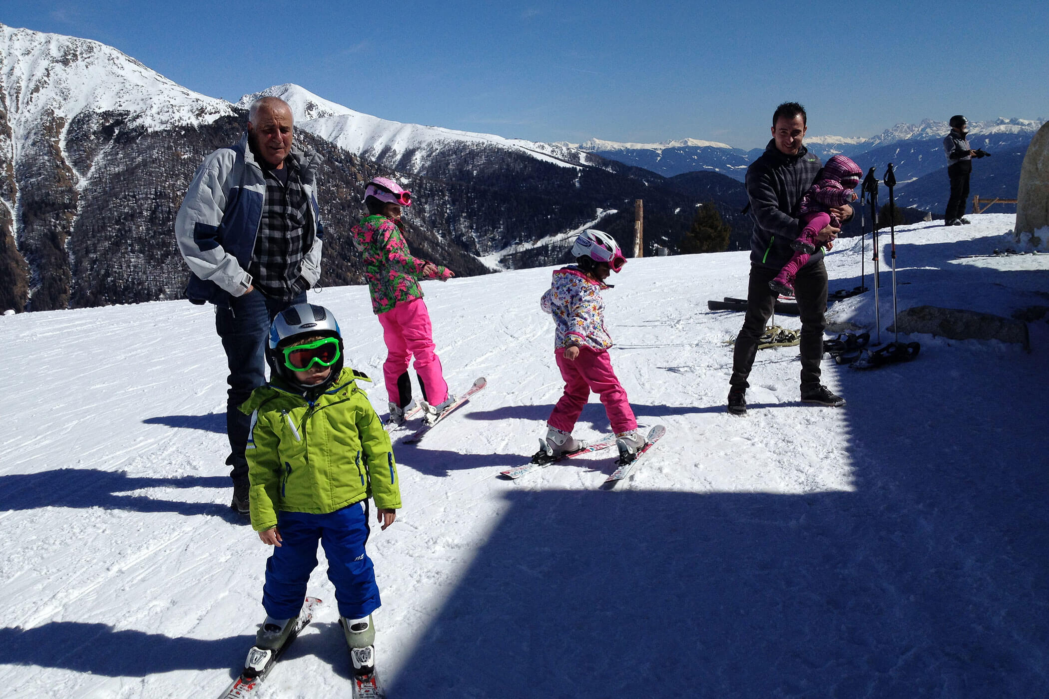 Kinder und Eltern stehen mit ihren Skiern auf der Piste - Scheaterhof