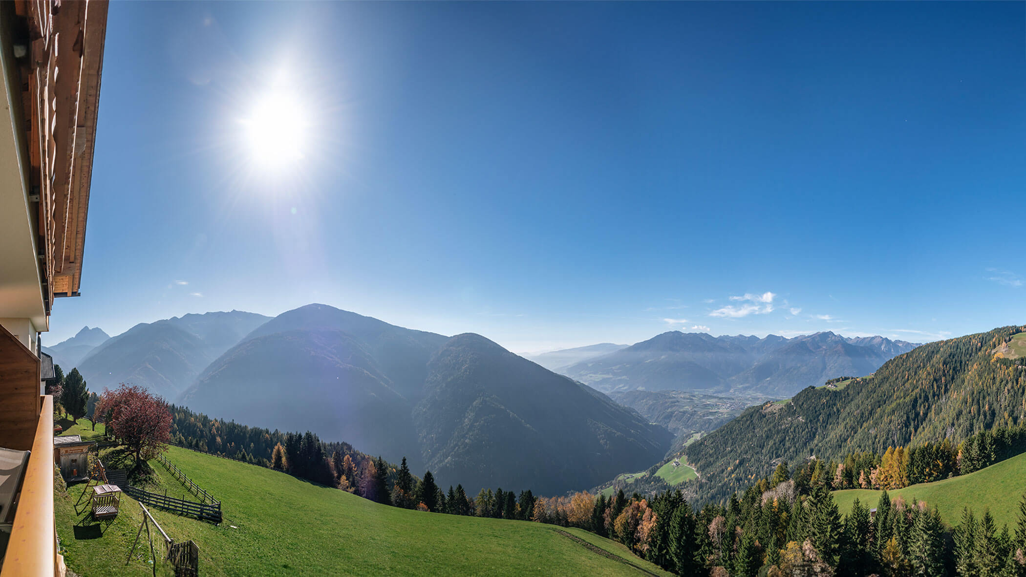 Ausblick vom Scheaterhof auf die Berge und Bäume im Sonnenschein
