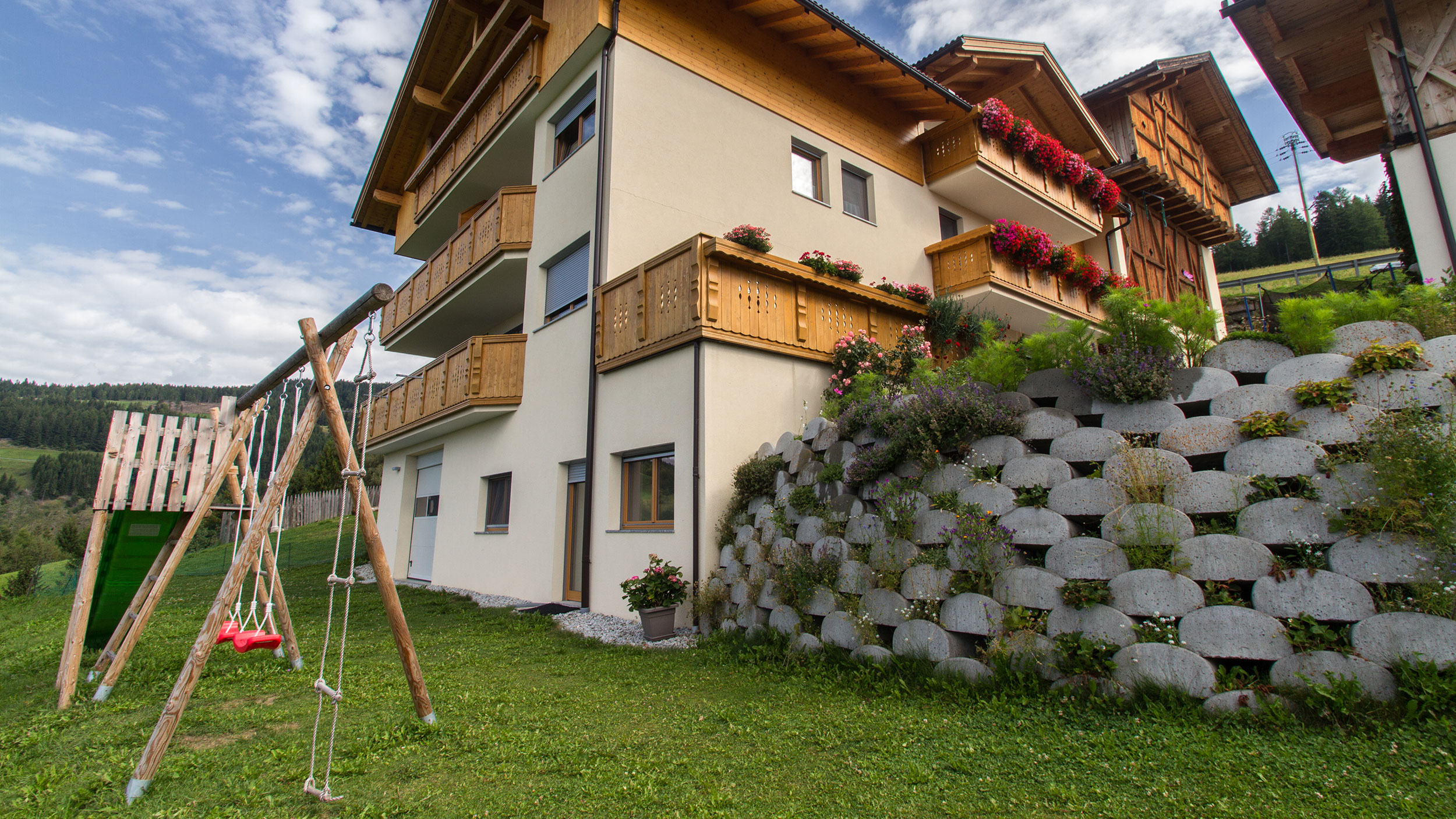 Kleiner Spielplatz mit Schaukel und Rutsche vor dem Scheaterhof
