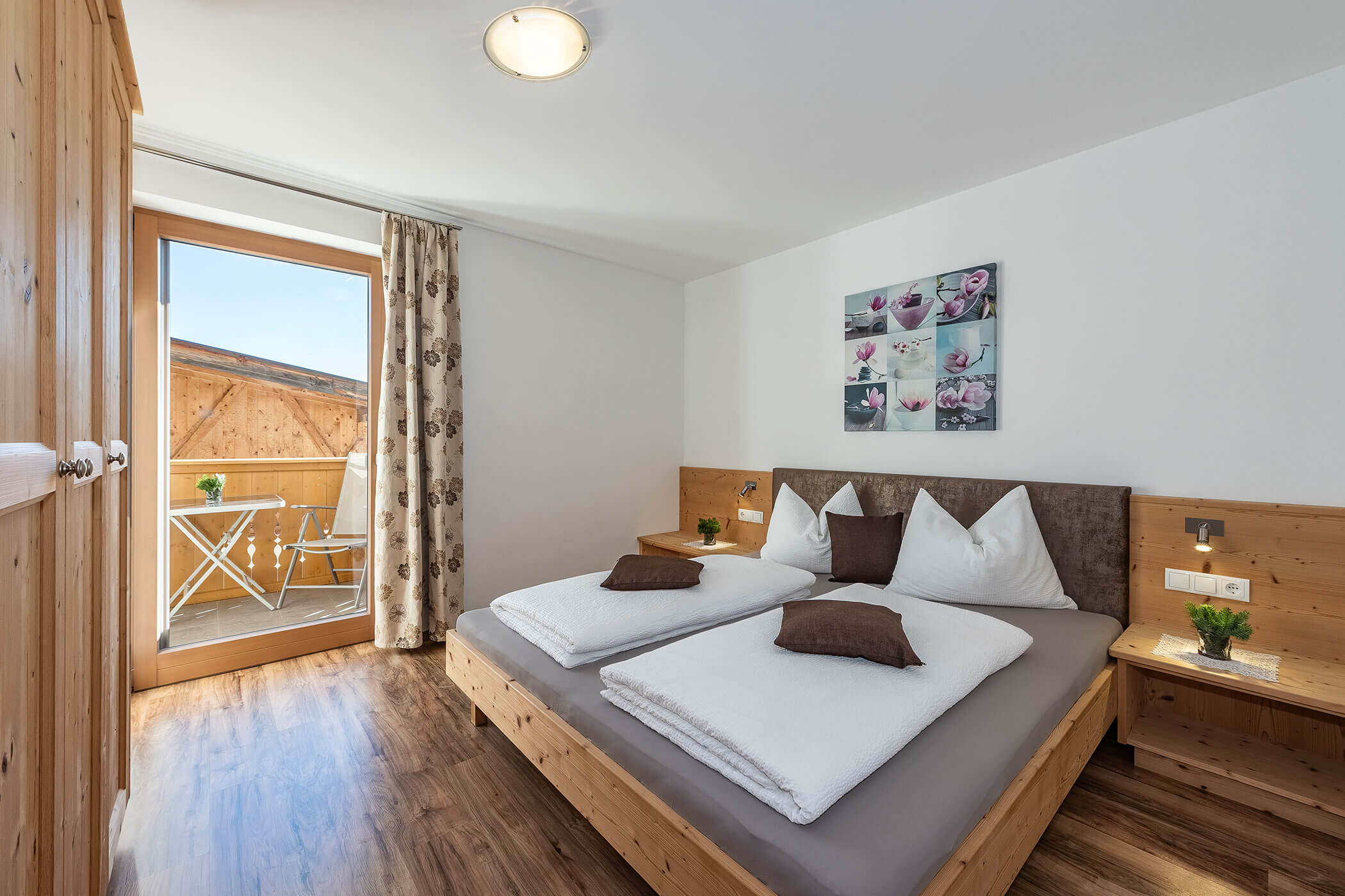 Schlafzimmer in der Ferienwohnung Peitlerkofel mit Doppelbett und Bild darüber - Scheaterhof