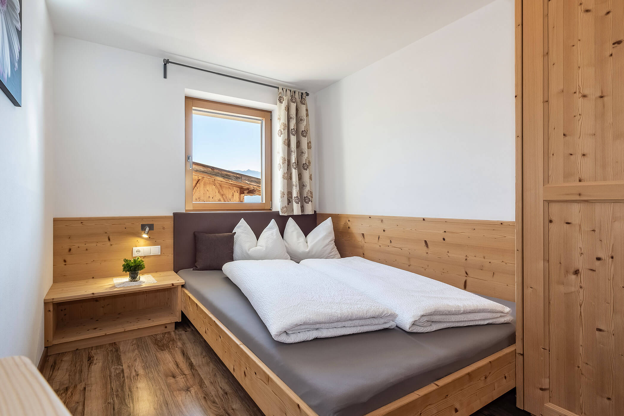 Schlafzimmer in der Ferienwohnung Peitlerkofel mit französischem Bett und Holzschrank - Scheaterhof