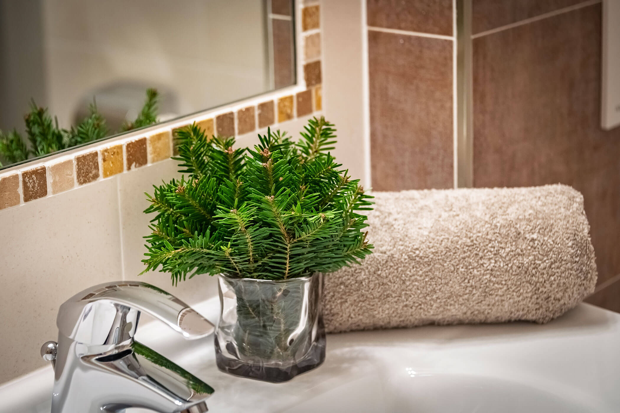 Bad in der Ferienwohnung Peitlerkofel mit Waschbecken, Handtuch und Dekoration - Scheaterhof